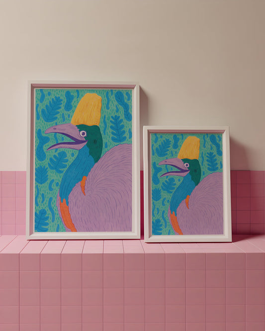 Two colorful framed artworks of a stylized bird on a pink tiled surface with a light pink wall background.
