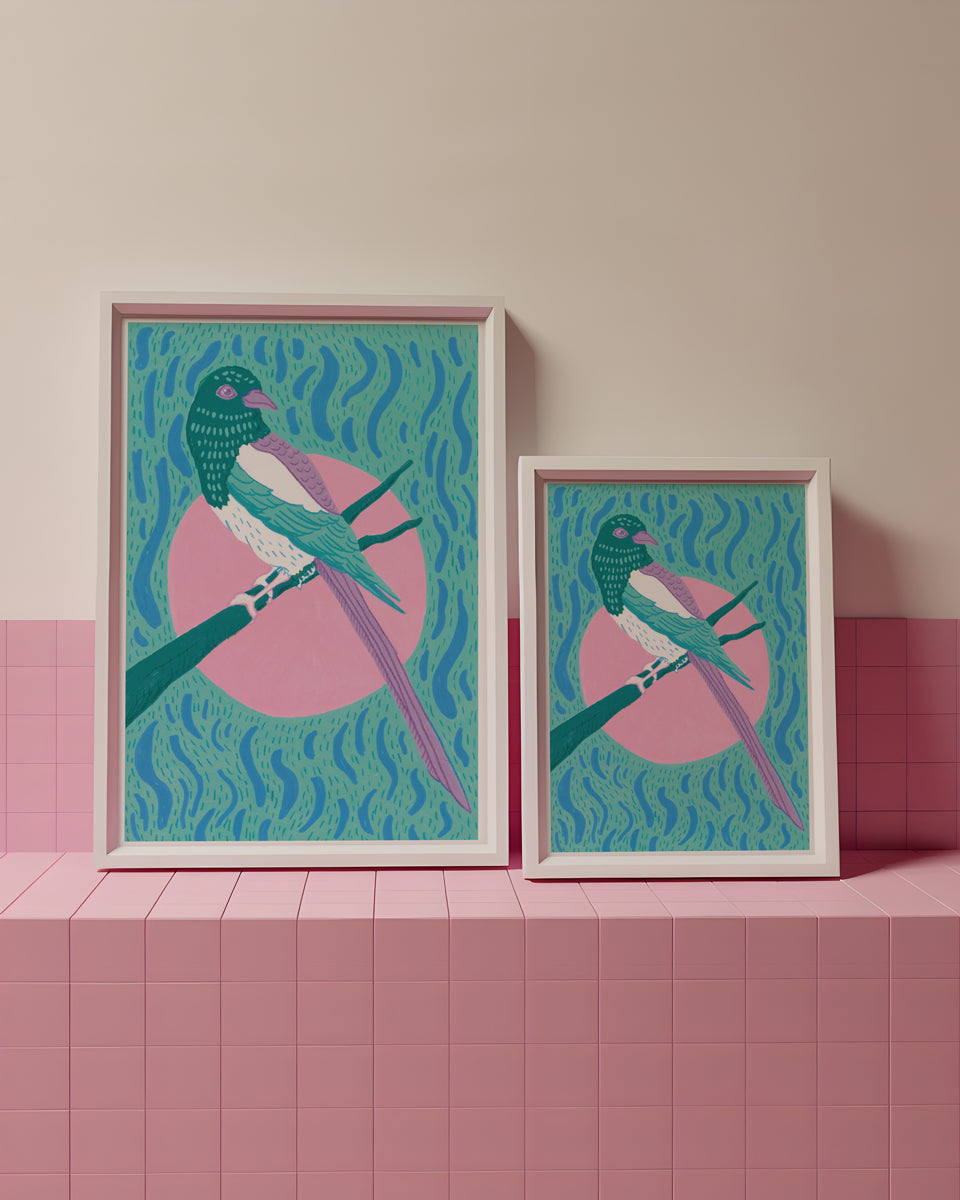 Two framed artworks of Magpies on a pink tiled shelf with a beige wall.