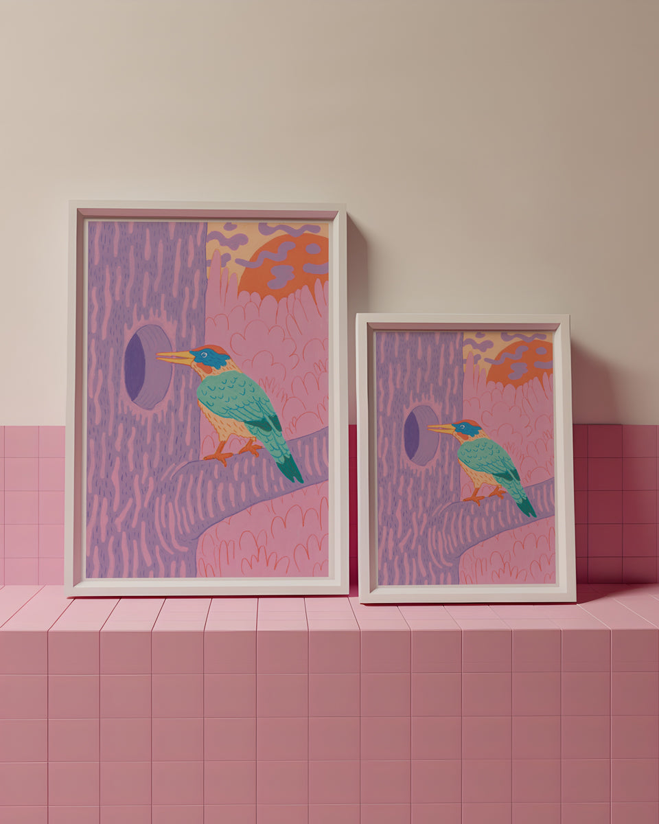 Two framed artworks with bird designs on a pink tiled surface and wall.