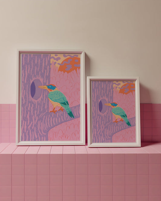 Two framed artworks with bird designs on a pink tiled surface and wall.