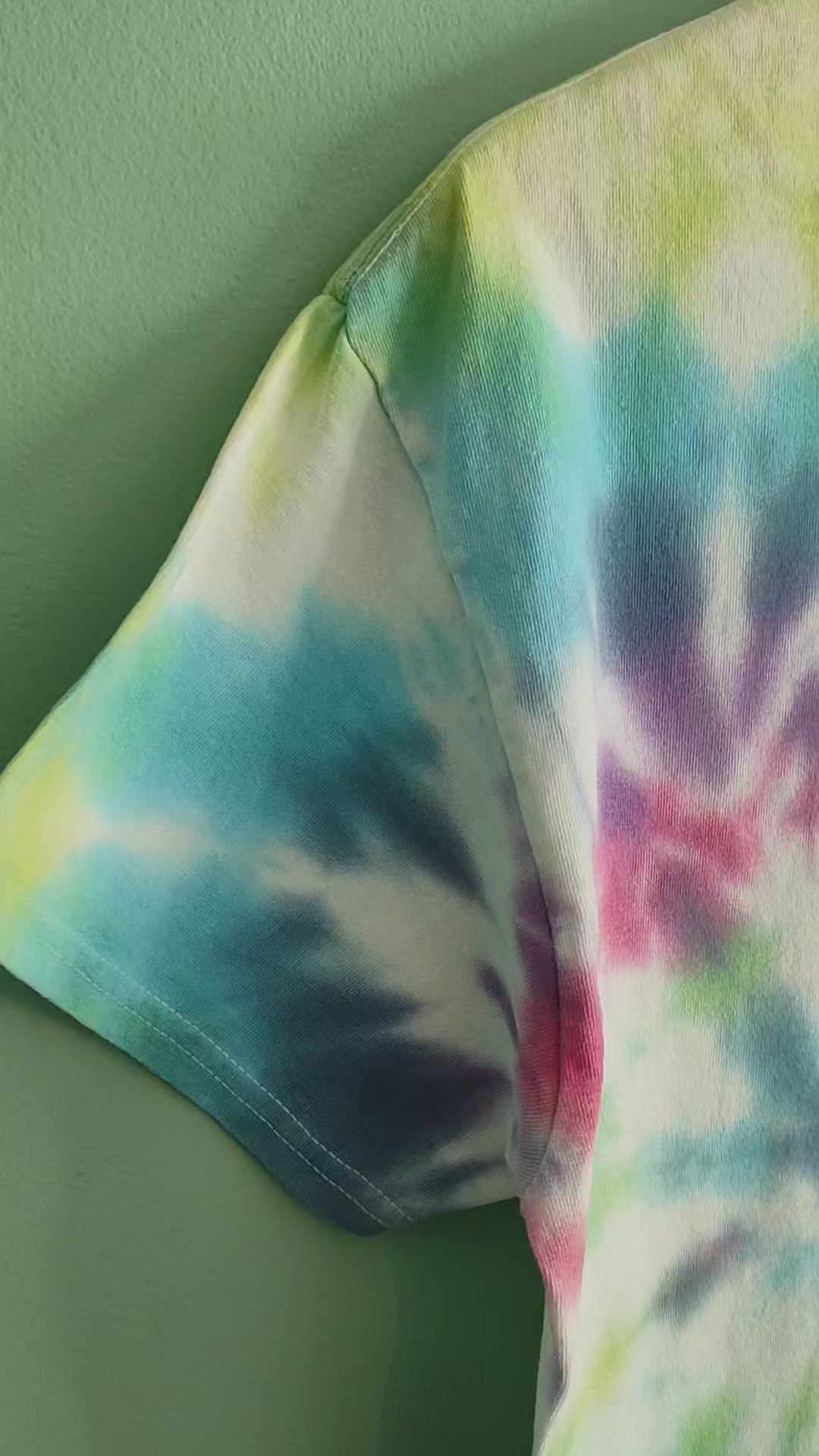 A video of a colourful tie dye tshirt featuring a grest crested grebe