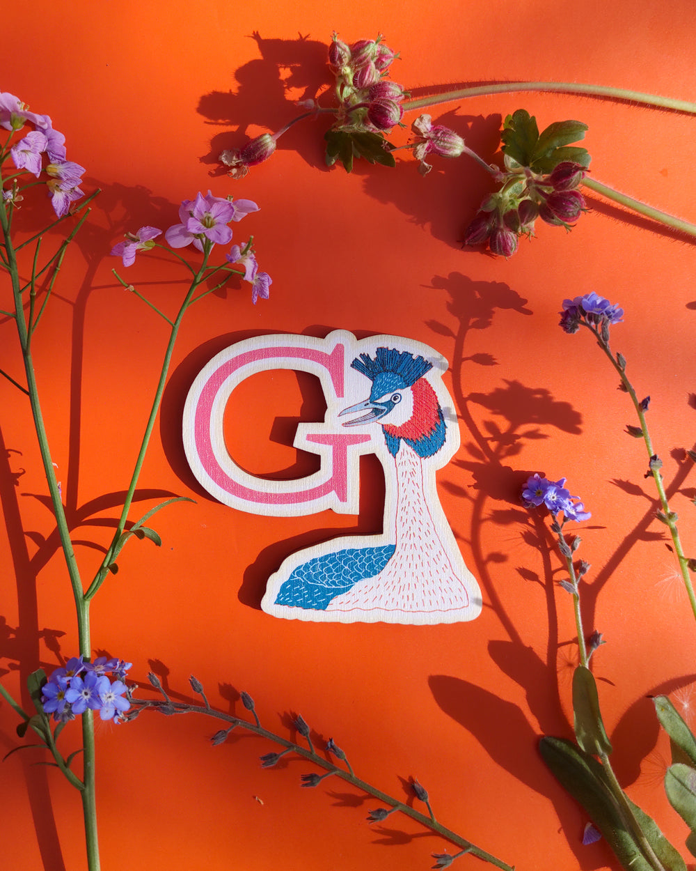 Letter 'G' design with flowers on an orange background