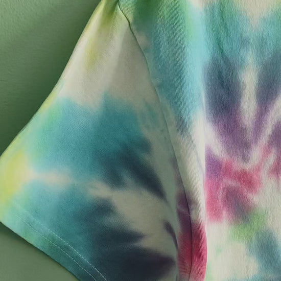 A video of a colourful tie dye tshirt featuring a grest crested grebe